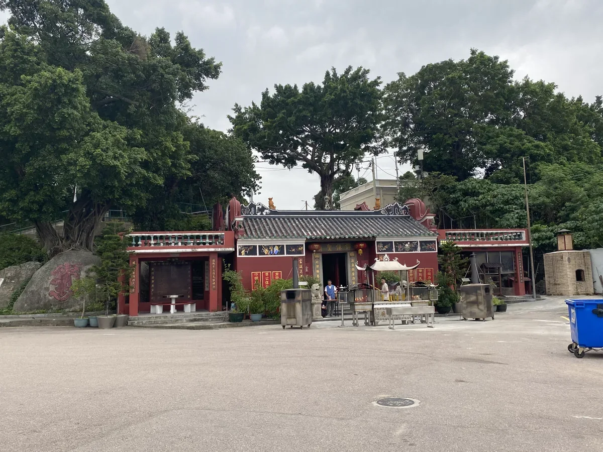 Front of Tam Kung Temple in Coloane, with a tiled roof and trees behind